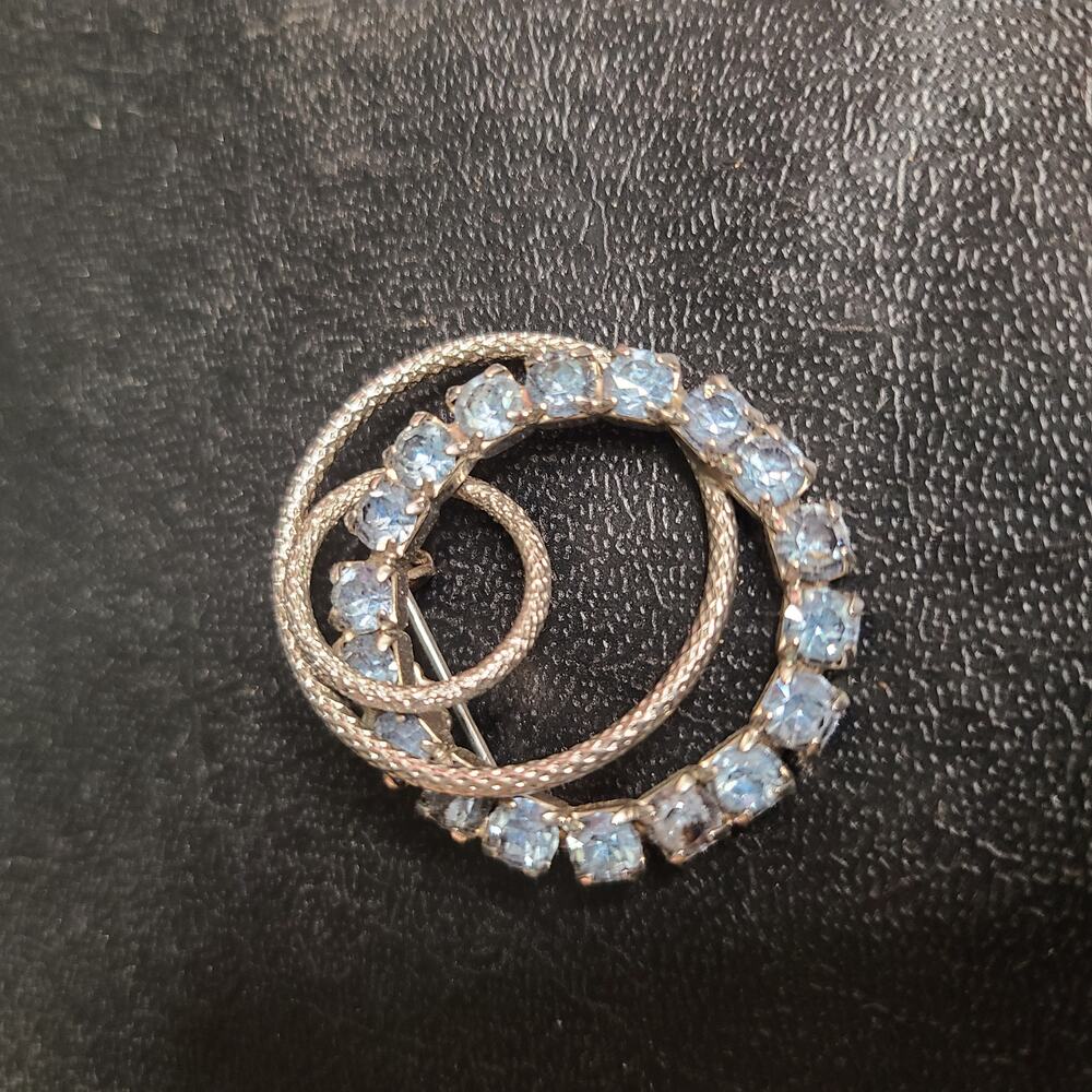 Vintage rhinestone round brooch with silver winding design
